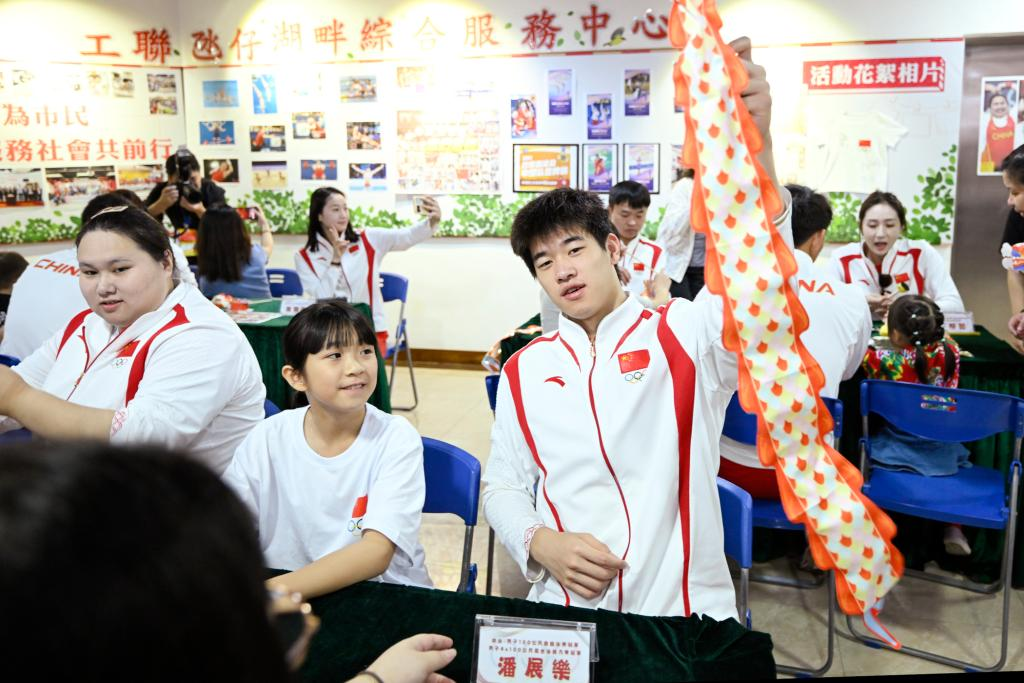 9月2日，在澳门工联氹仔湖畔综合服务中心，游泳运动员潘展乐（右）展示与小朋友一起制作的灯笼。当日，内地奥运健儿代表团走进澳门社区，分别到妇联乐满家庭服务中心、街总石排湾家庭及社区综合服务中心和工联氹仔湖畔综合服务中心与市民互动。新华社发