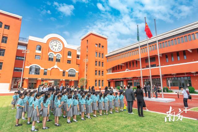 澳门新生身穿校服，背着书包来到濠江中学附属横琴学校报到。